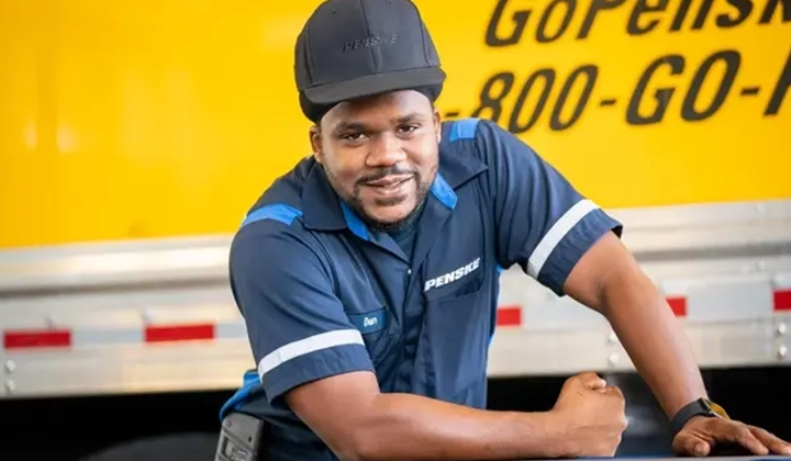 Happy Penske employee in front of Penske truck.